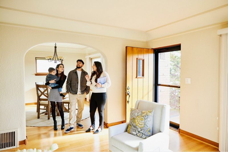 A family tours a bright and spacious home with a real estate agent.