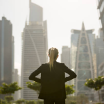 Person in a suit looking at modern skyscrapers, representing Dubai's real estate market and apartment values.