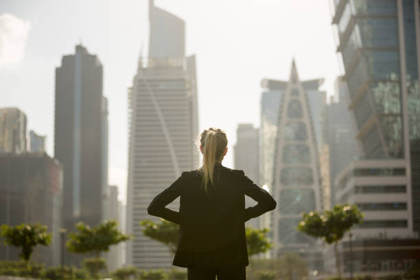 Person in a suit looking at modern skyscrapers, representing Dubai's real estate market and apartment values.