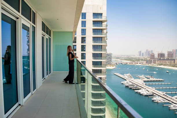 Person standing on a balcony overlooking Dubai Marina, illustrating spaciousness of one-bedroom apartments.